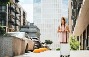 Pourquoi souscrire une assurance voyage avec rapatriement sanitaire ? Assurance voyage rapatriement - Jeune femme avec une valise