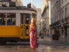 Visiter le Portugal en 2025 : vivez une expérience authentique Jeune touriste blonde regardant passer le tramway jaune typique de Lisbonne dans la rue du centre ville sur la Rua Augusta.